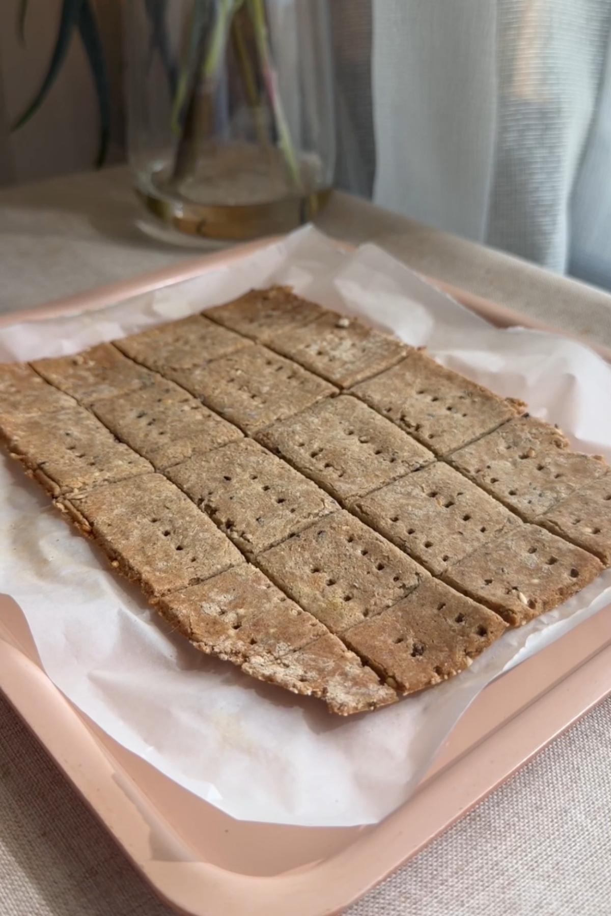 Baked crackers scored into rectangles on a parchment-lined tray.