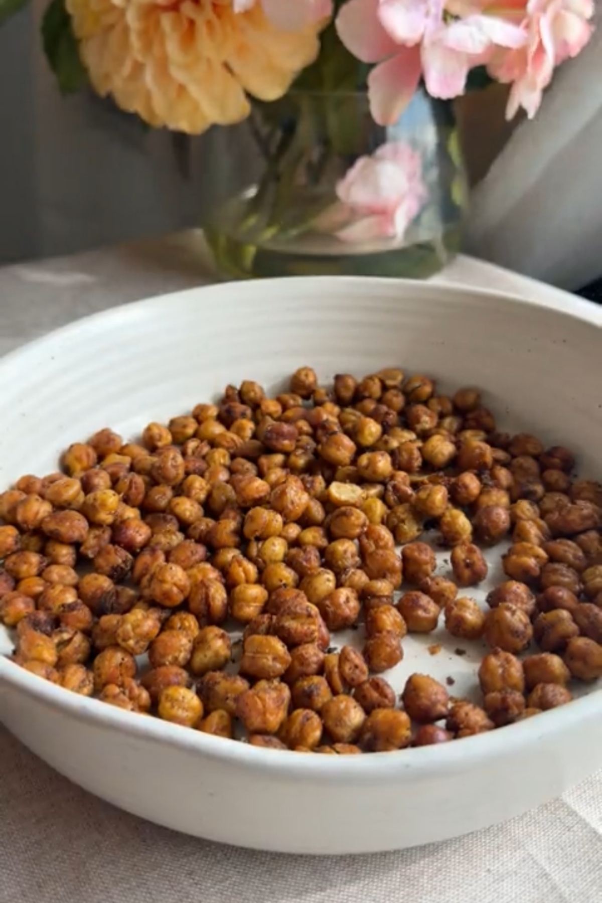 Crispy chickpeas scattered across a shallow white serving bowl.