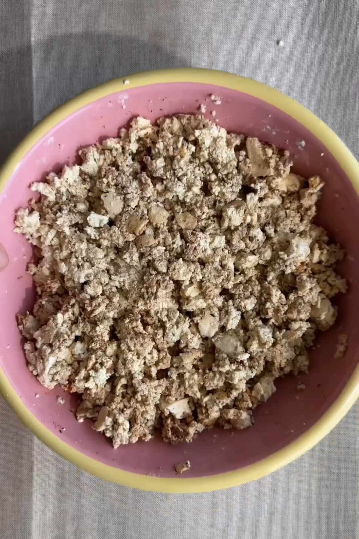 Crumbled seasoned tofu in a bowl before baking until crispy.