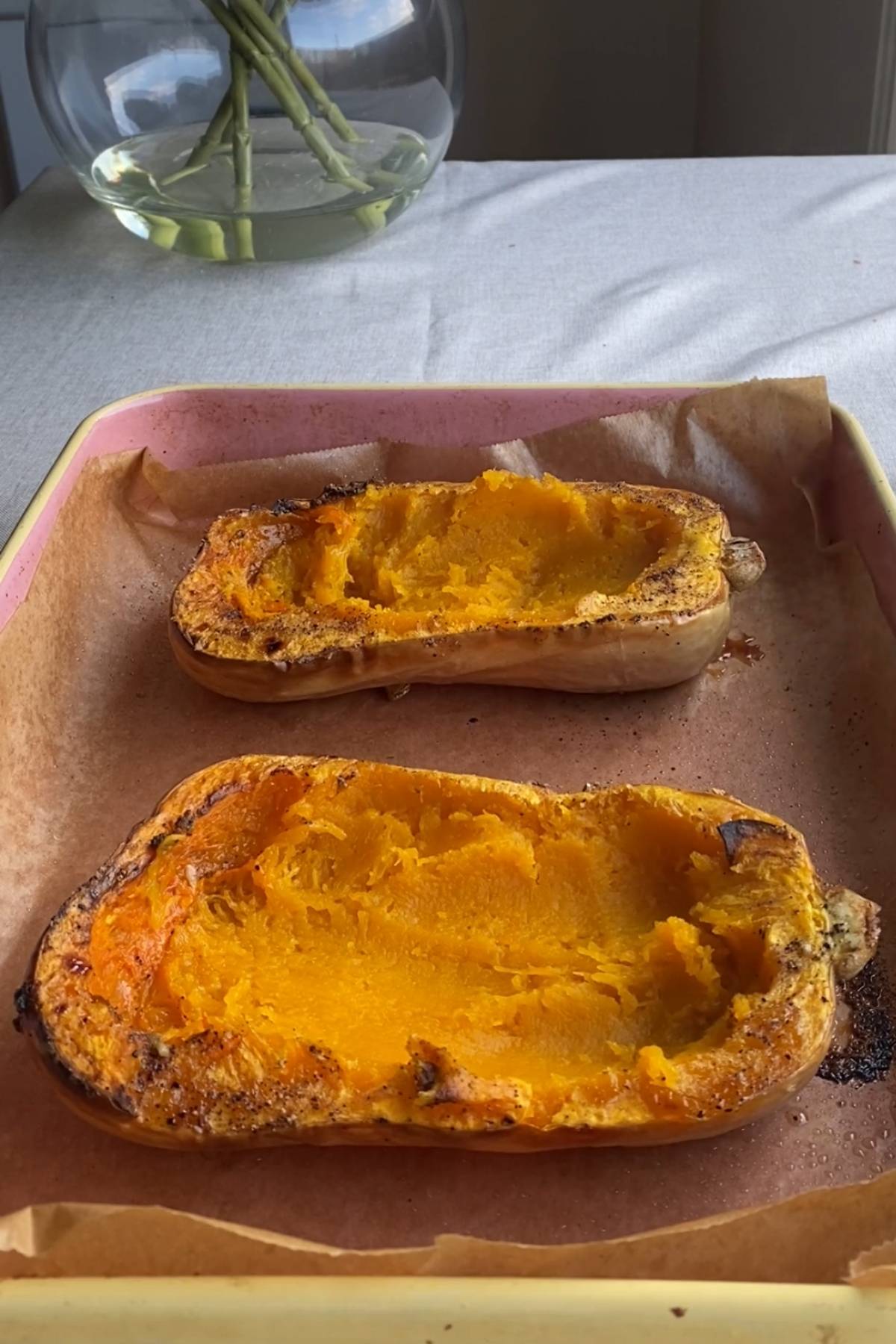 Roasted butternut squash halves with the flesh scooped out, ready for filling.