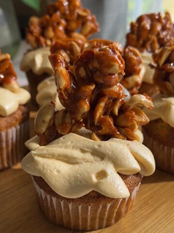 Cupcake with peanut butter frosting topped with peanut brittle.