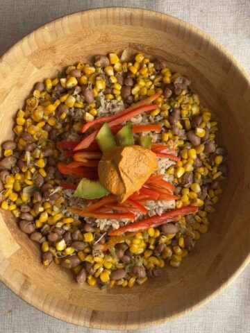 Brown rice bowl with corn, pinto beans, avocado, red bell pepper, and creamy chipotle dressing.