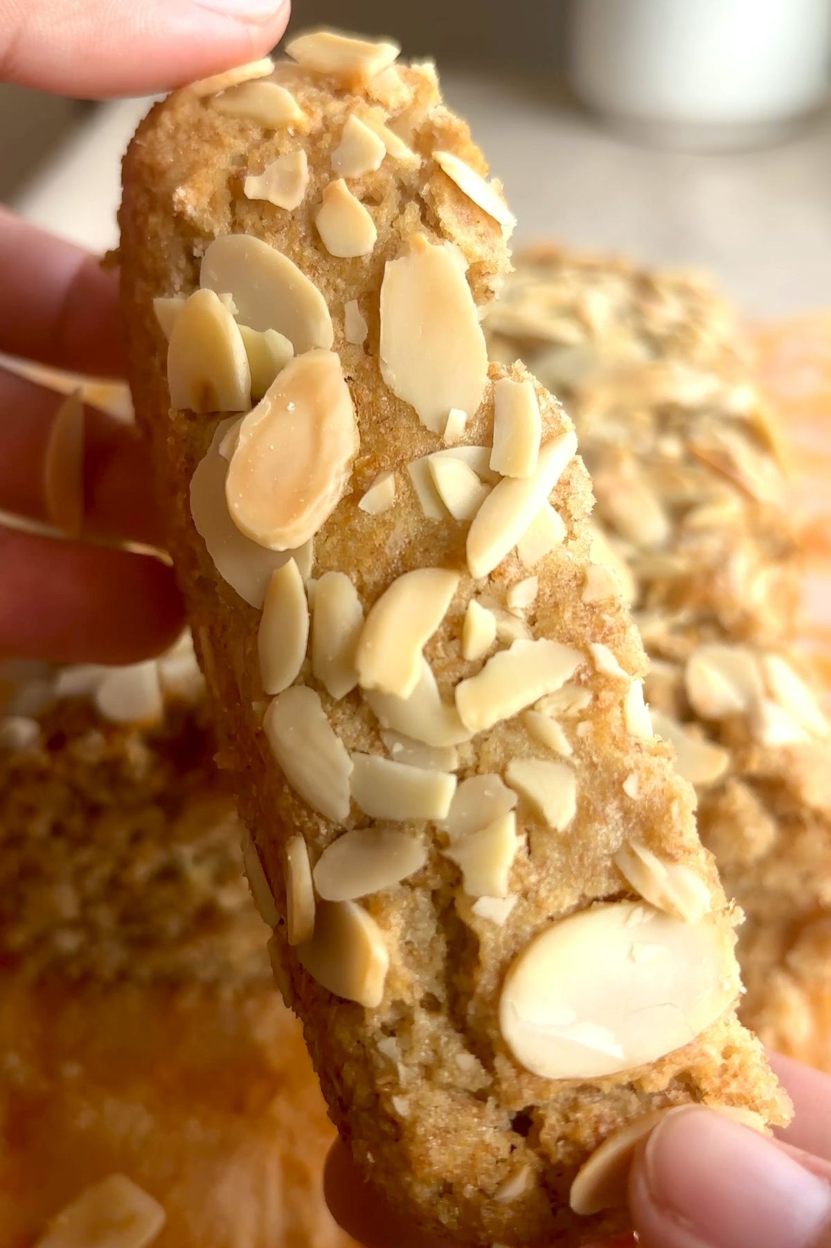 Close-up of a gluten-free lemon loaf slice topped with toasted sliced almonds.