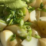 Baby potatoes topped with sliced green onions and creamy green herb dressing.