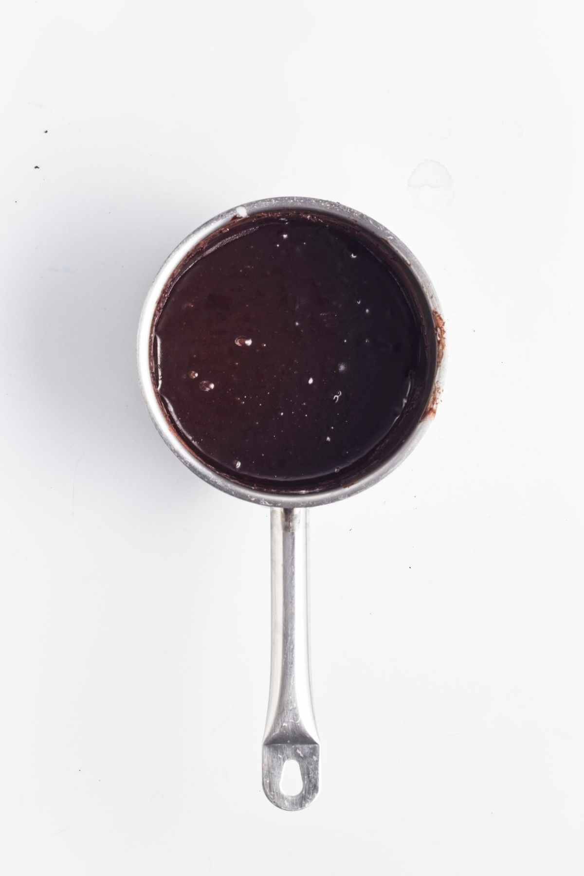 Glossy chocolate icing in a small saucepan.