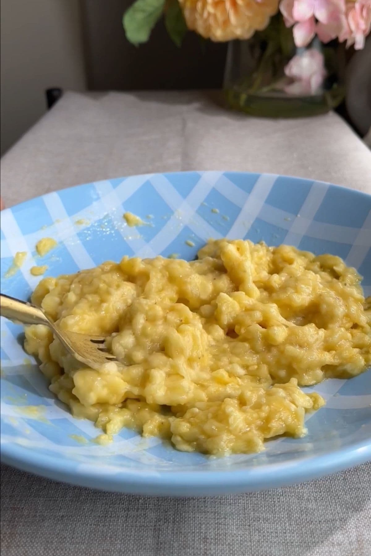 Mashed banana in a blue bowl with a fork.