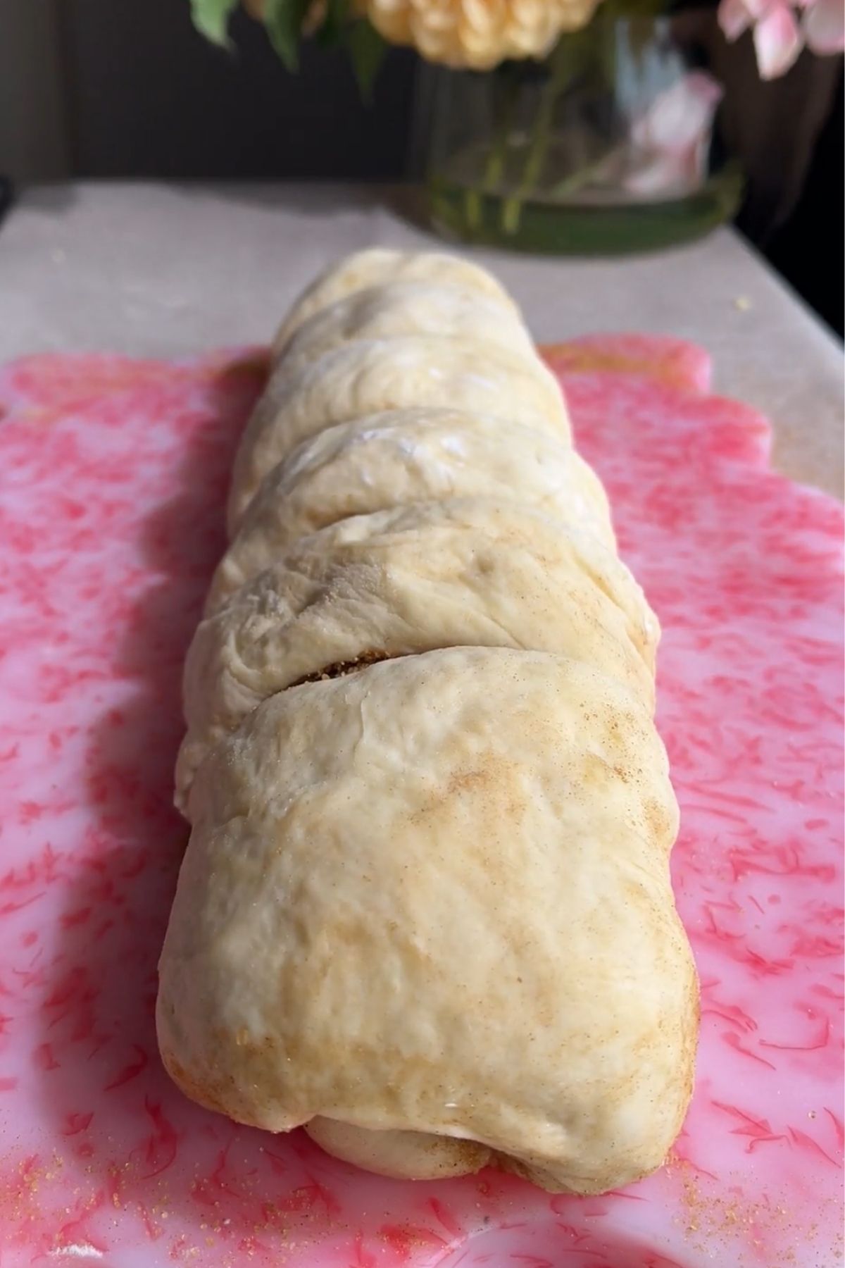 Rolled cinnamon roll dough log cut into sections.