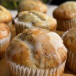 Glazed lemon poppy seed muffin with icing dripping down the sides.
