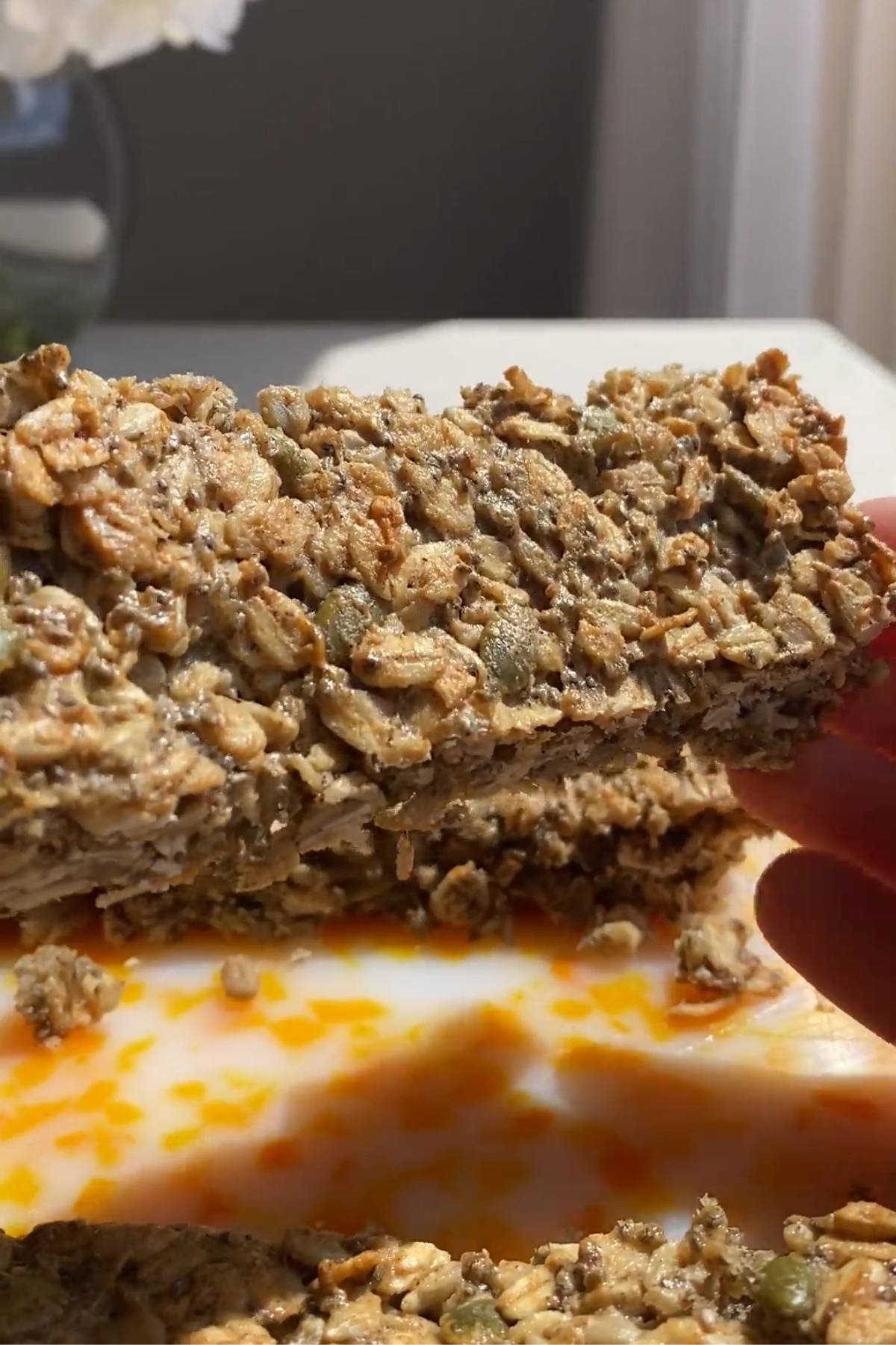 Close-up of a sliced nut-free granola bar showing its chewy oat, chia, sunflower seed, and pumpkin seed texture.