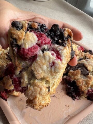 Large raspberry chocolate scone showing juicy raspberries and melted dark chocolate.