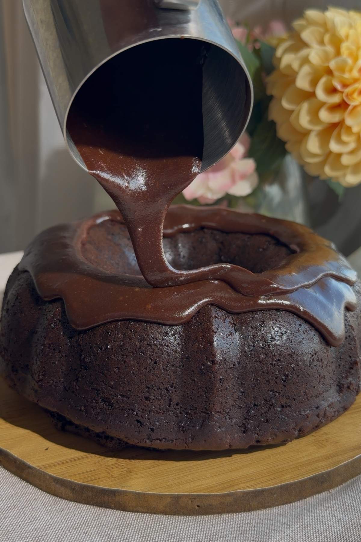 Chocolate Bundt cake coated with glossy chocolate icing.