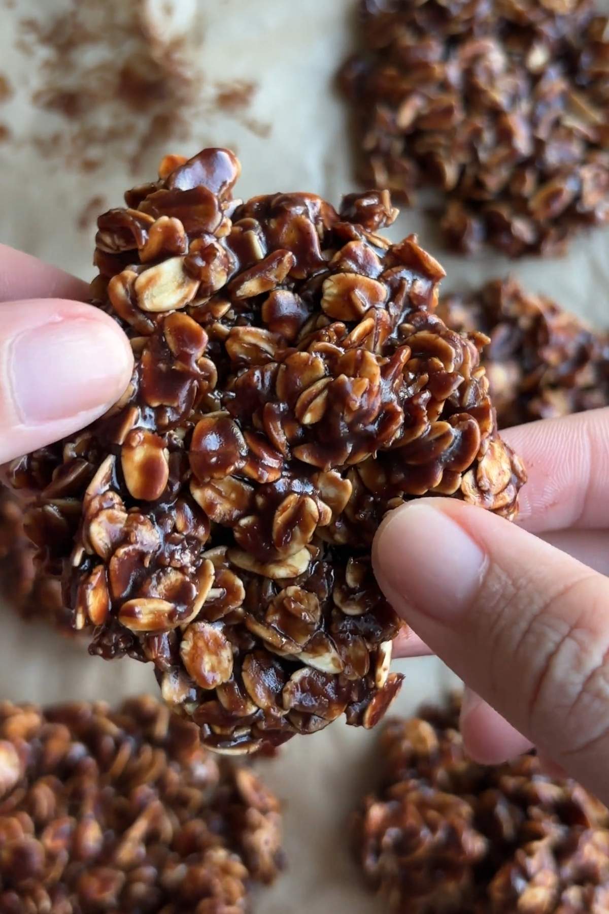 Close-up of a chocolate no bake cookie held between two fingers.