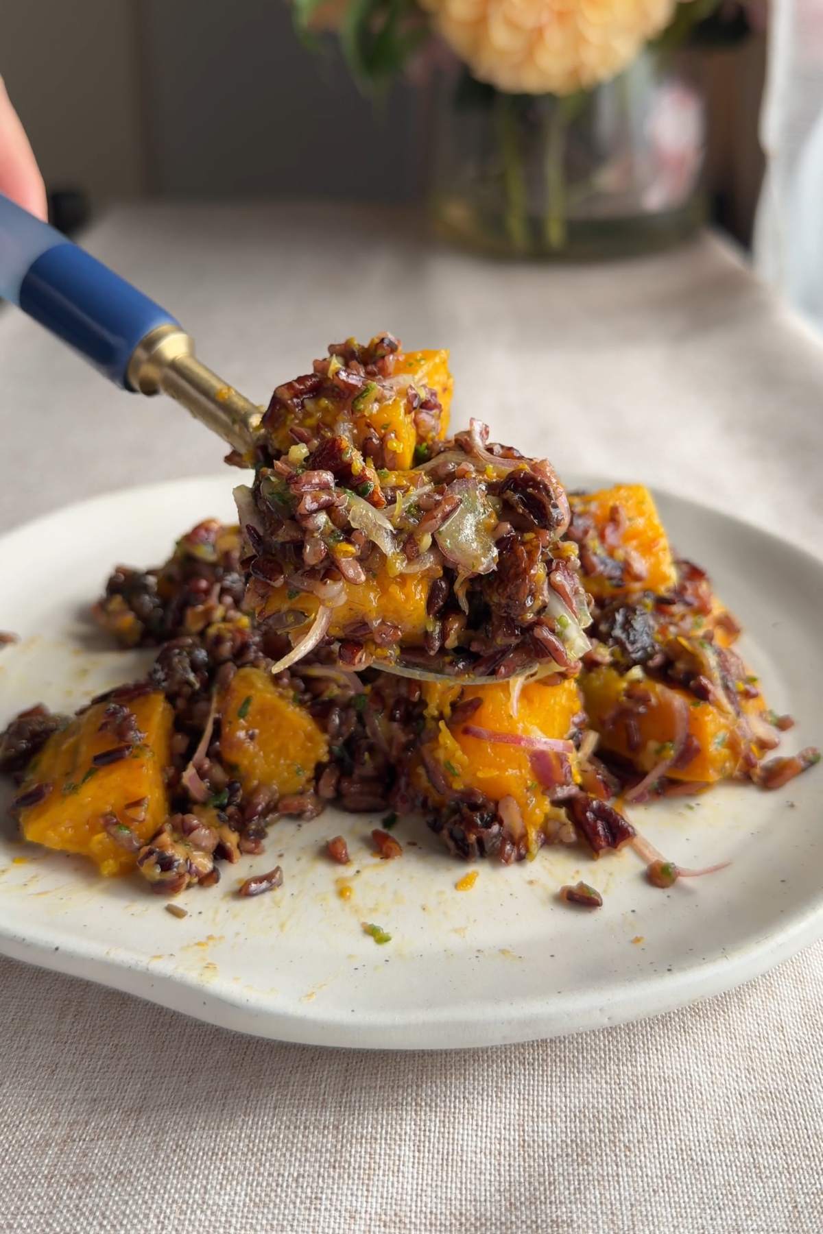 Close-up of wild rice salad with roasted butternut squash on a spoon.