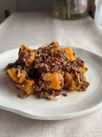 Wild rice salad with roasted butternut squash served on a white plate.