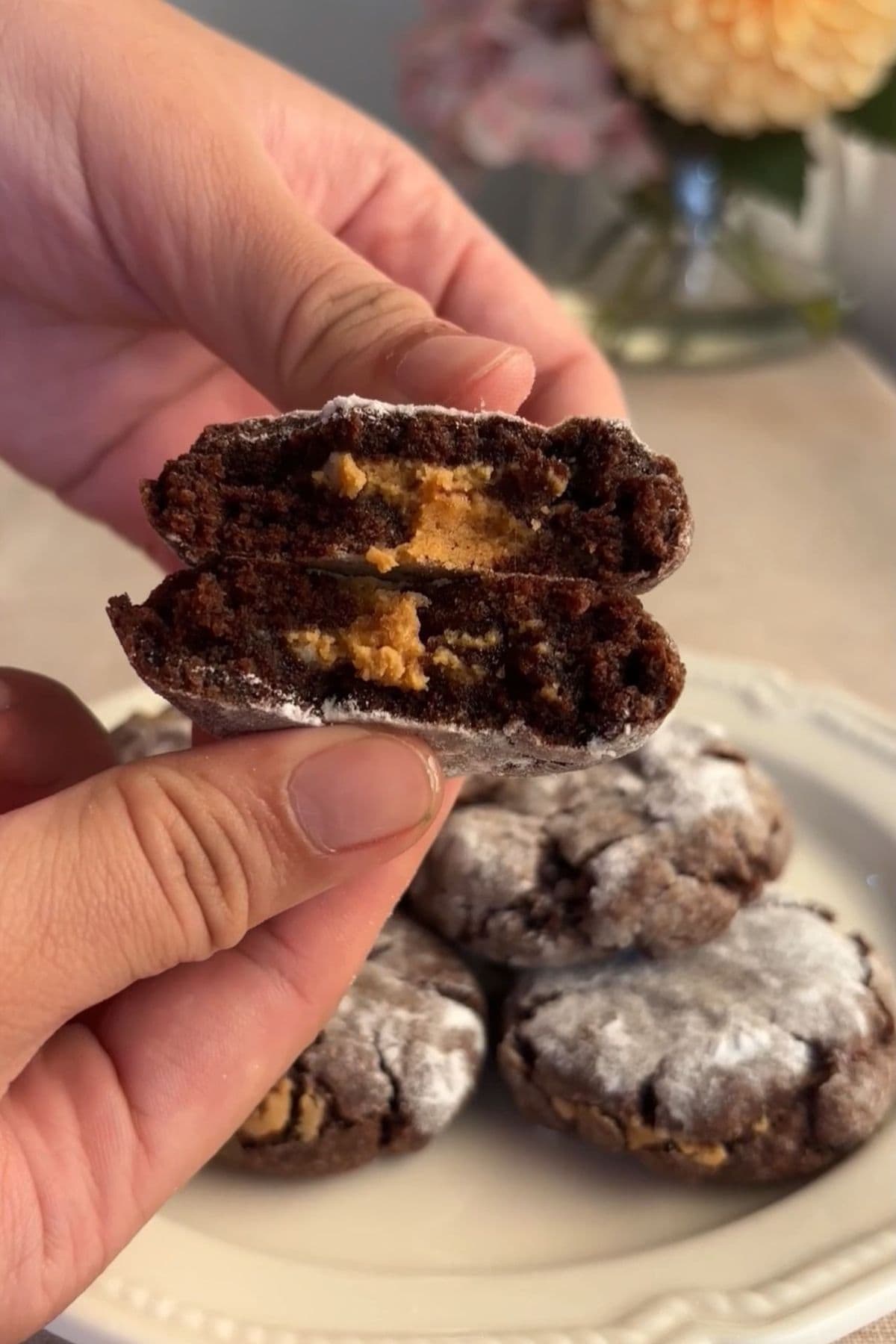 Close-up of a halved chocolate crinkle cookie showing a peanut butter center.
