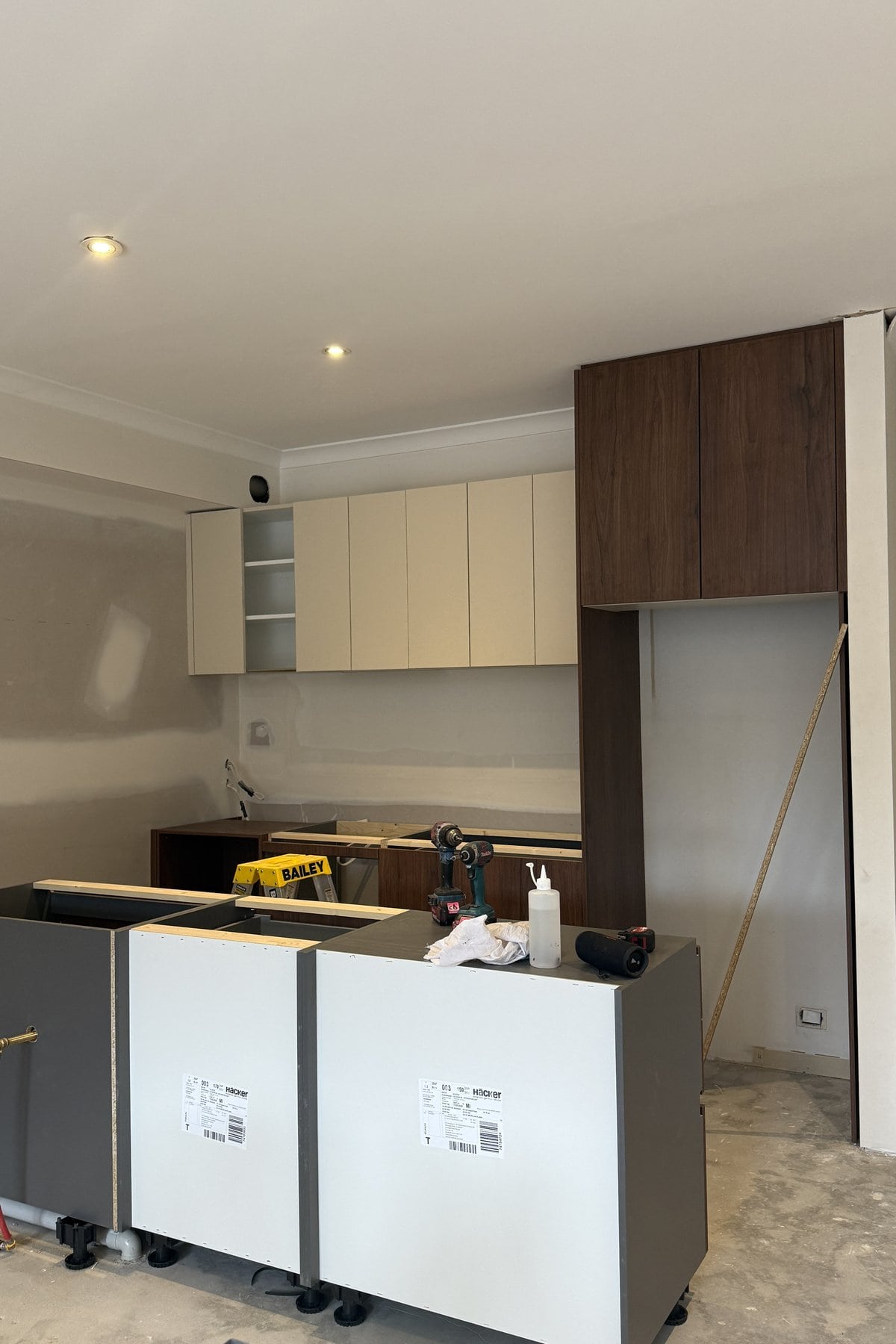 Bone upper cabinet doors fitted beside tall walnut cabinetry.