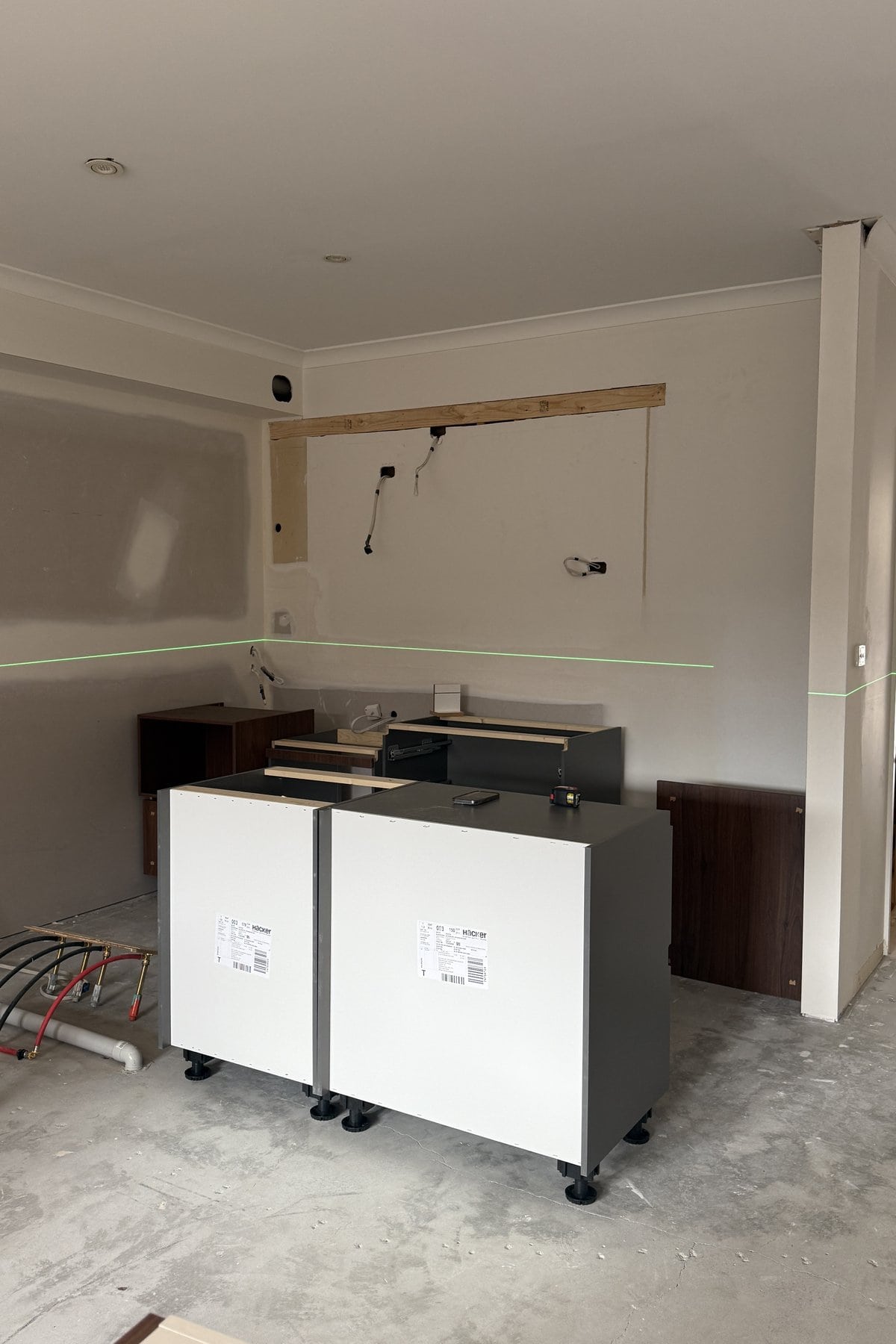 Walnut drawer units unwrapped on the floor beside boxed appliances.