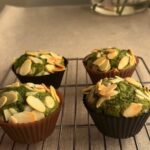 Side shot of four freshly baked matcha muffins in a cooling rack.