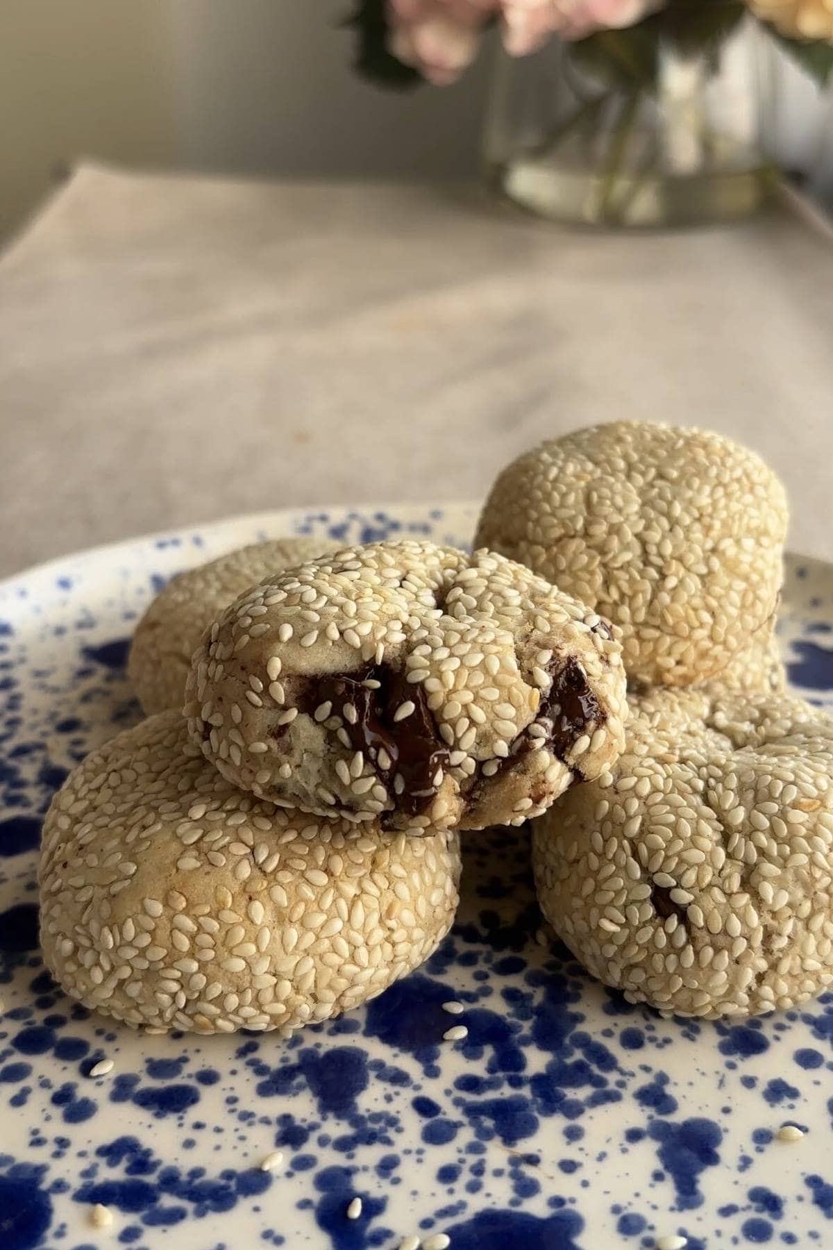 A cookie half stacked on whole cookies, showing melted chocolate chips inside.