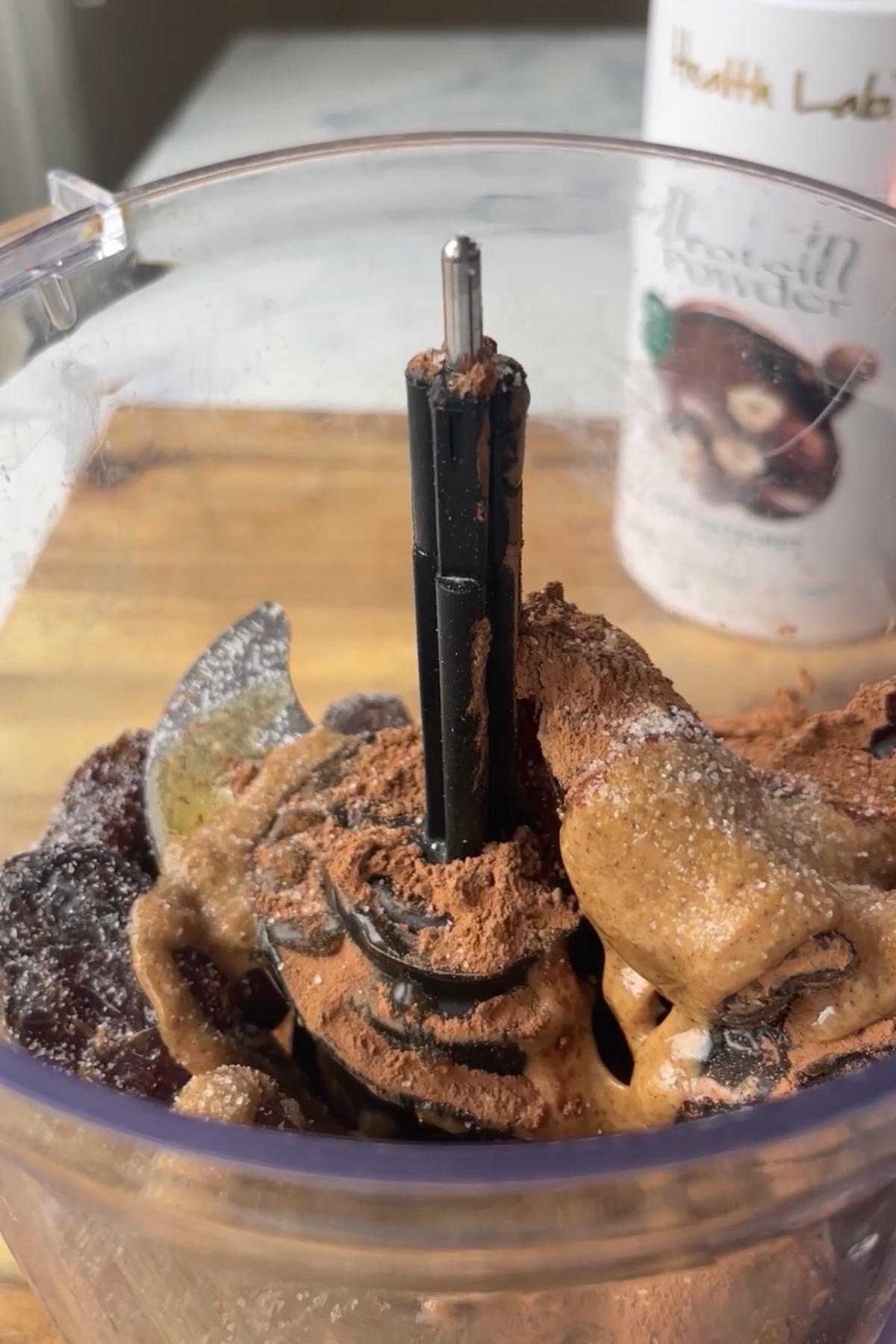 Dates, nut butter and cocoa powder in a food processor before blending.