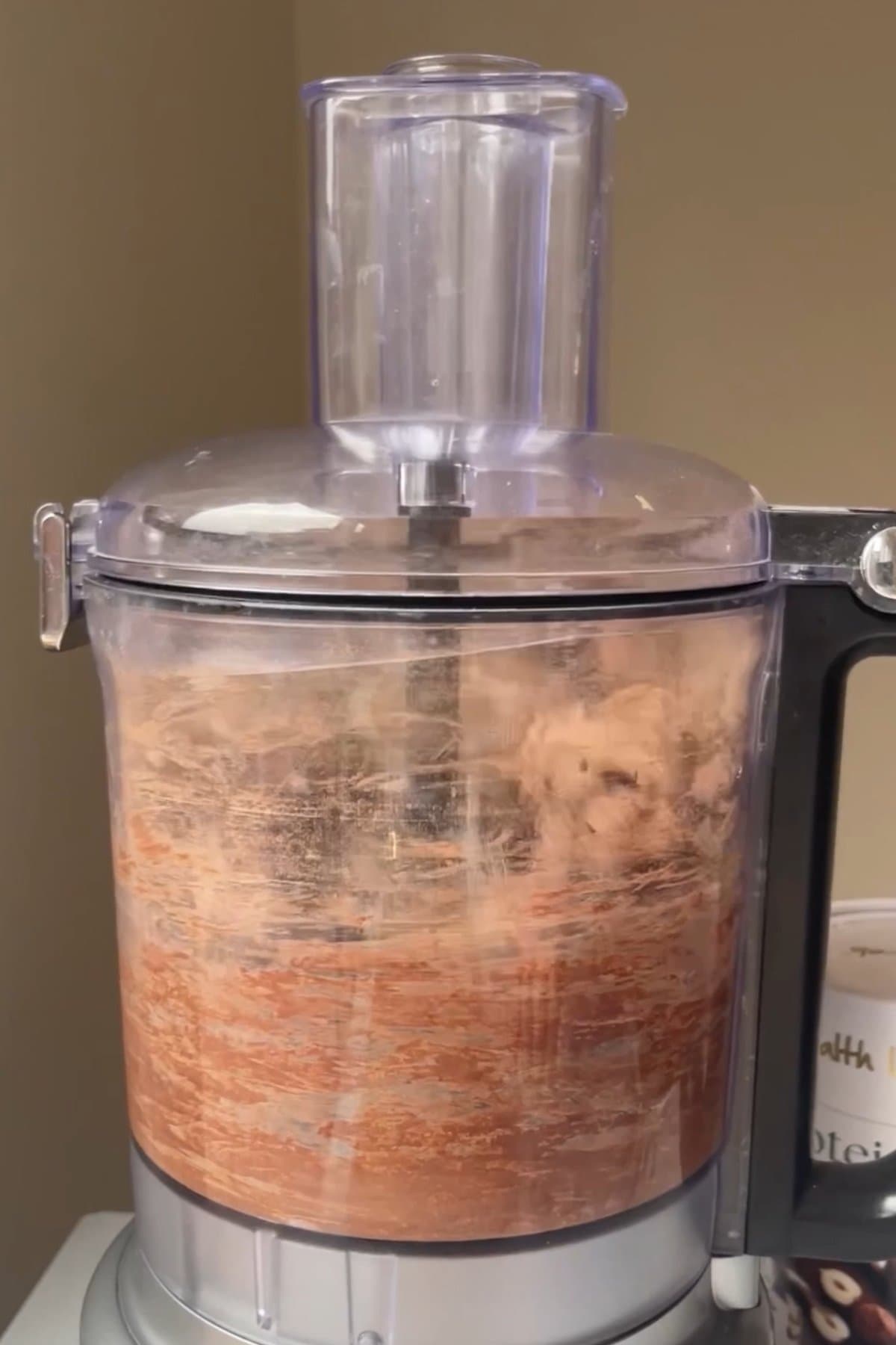 Blended chocolate protein mixture in a food processor.