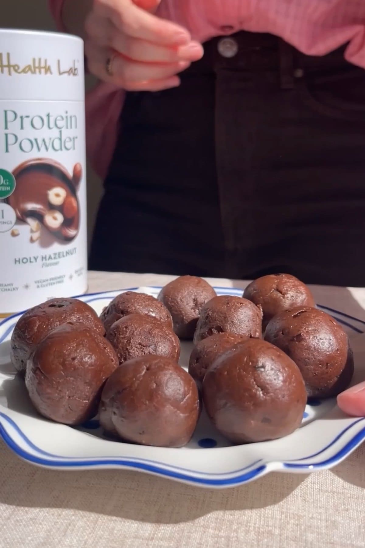 Rolled chocolate protein balls on a plate before coating.