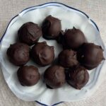 Overhead view of chocolate-coated balls on a lined plate.