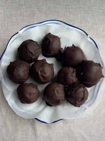 Overhead view of chocolate-coated balls on a lined plate.